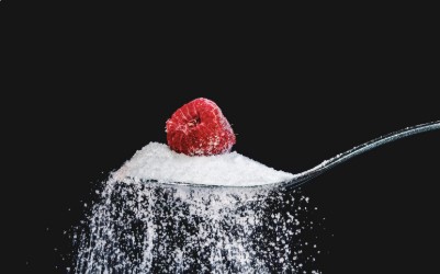 belle photo sur fond noir, cuillère de sucre avec une framboise