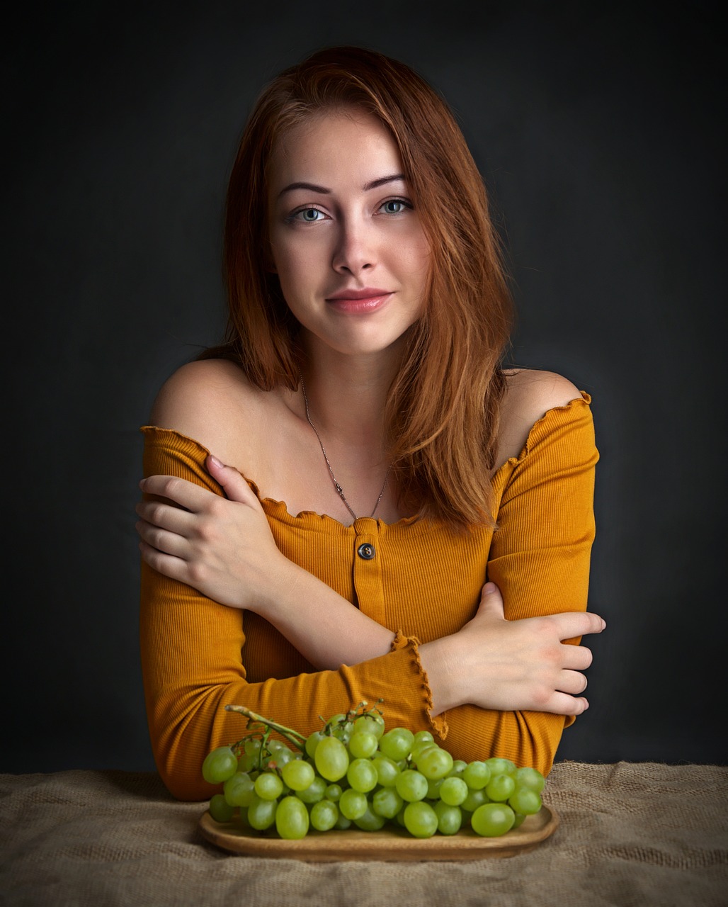 jolie jeune femme devant une assiette de raisin